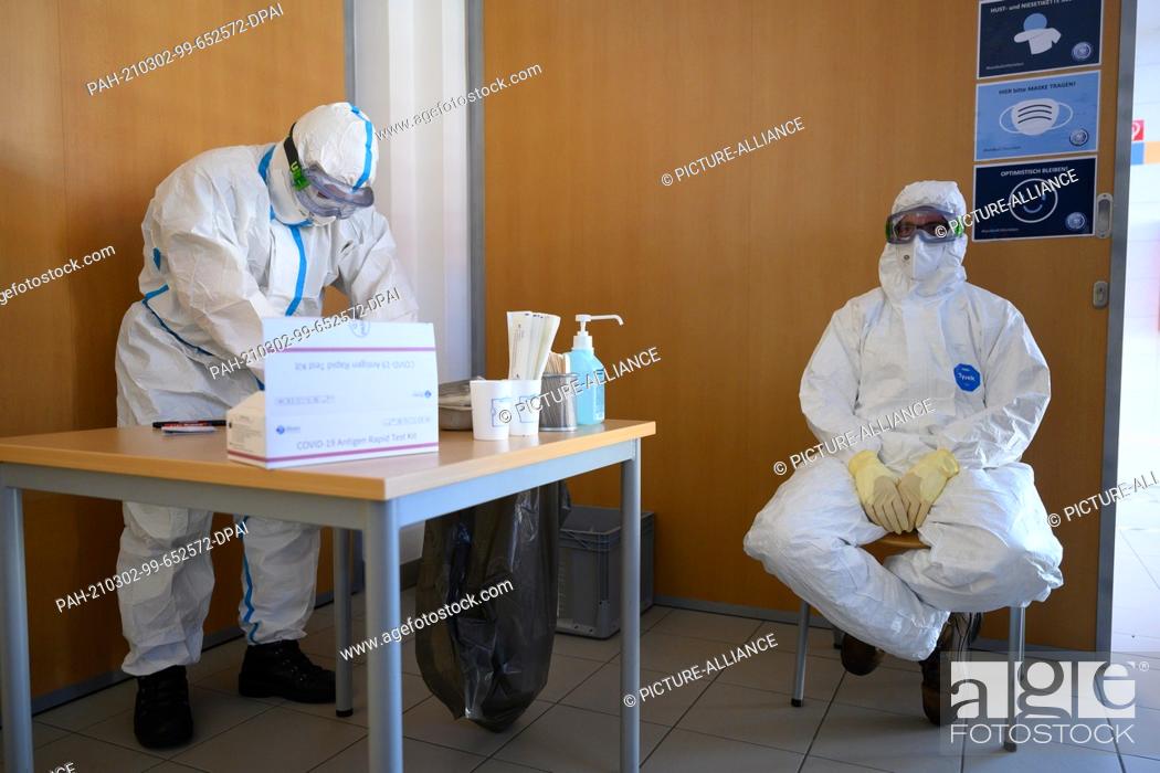 Stock Photo: 02 March 2021, Saxony, Radeberg: Health department employees prepare for a mass test for residents of the region in the gymnasium of the Radeberg vocational.