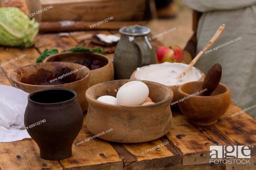 Stock Photo: Medieval food preparation including eggs, cream and fruit in wooden bowls or trenchers.