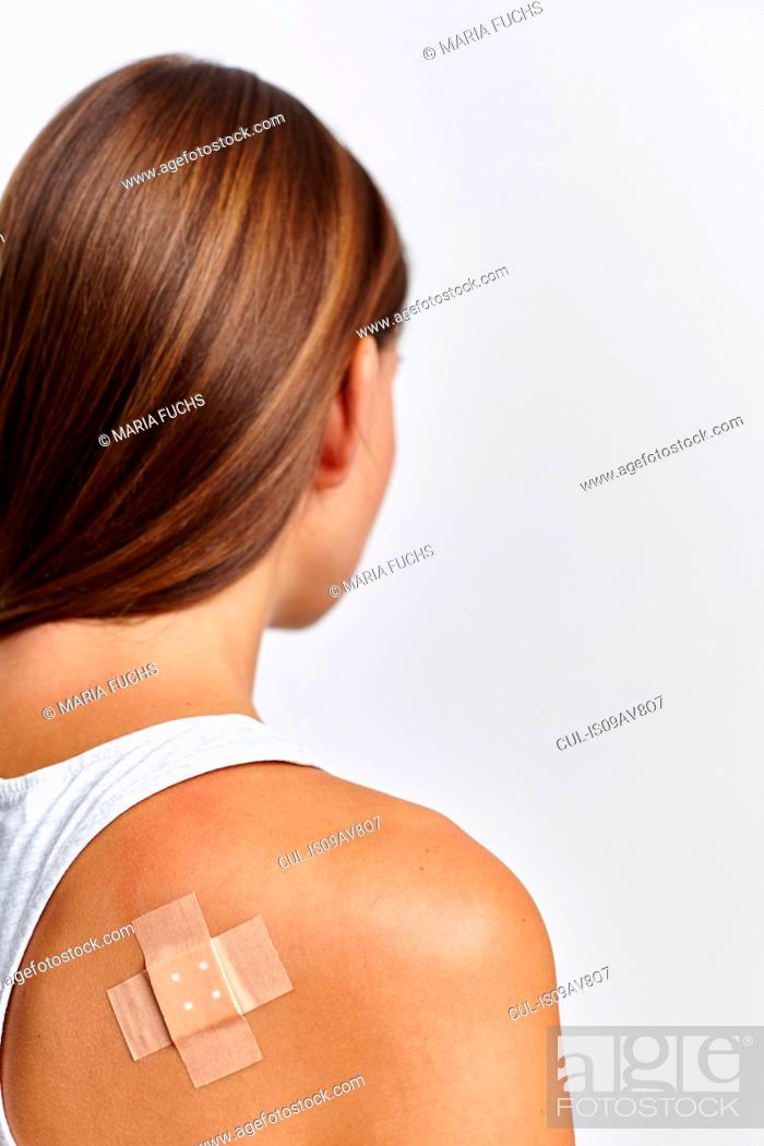 Stock Photo: Woman with plaster on back of right shoulder.