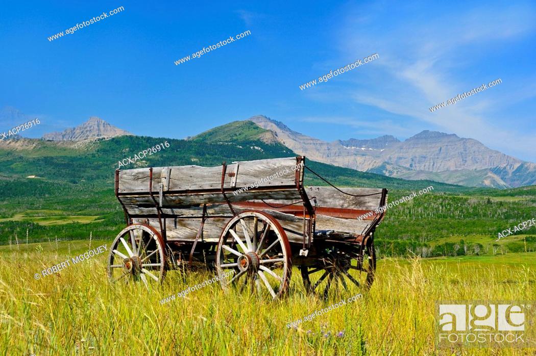 Stock Photo: This landscape image of an antique farm wagon sitting on a piece of ranchland in southern Alberta gives a look into travel of the pioneers in early Canada.
