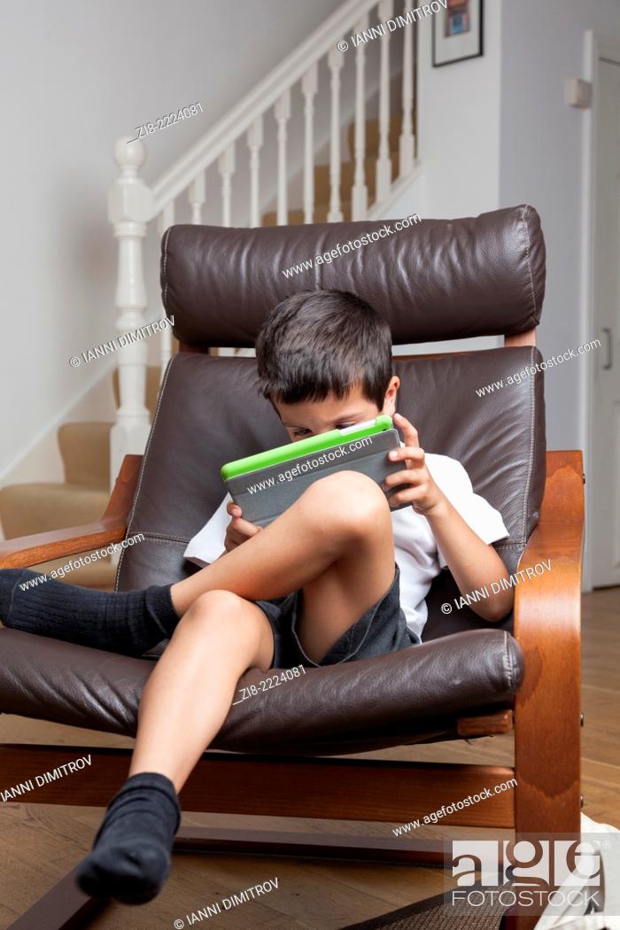 Stock Photo: Boy plays on a tablet at home.
