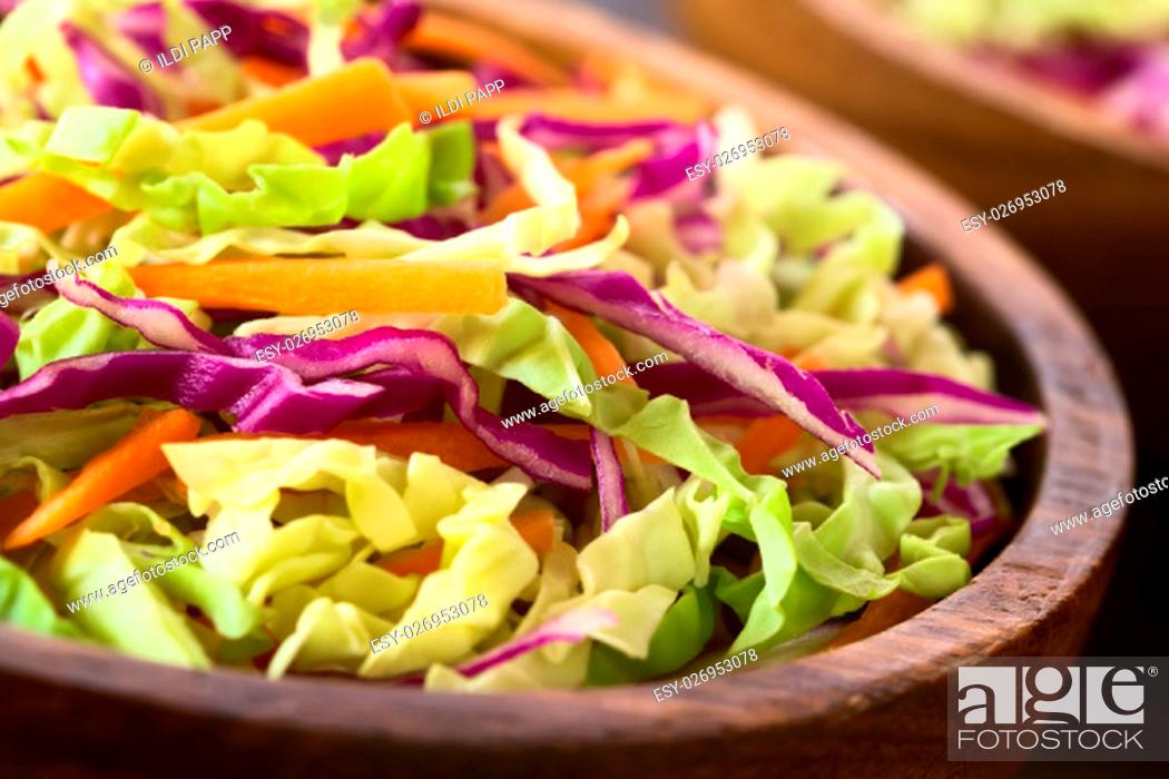Stock Photo: Fresh coleslaw, a salad made of shredded red and white cabbage and carrots, served in wooden bowl, photographed with natural light (Selective Focus.