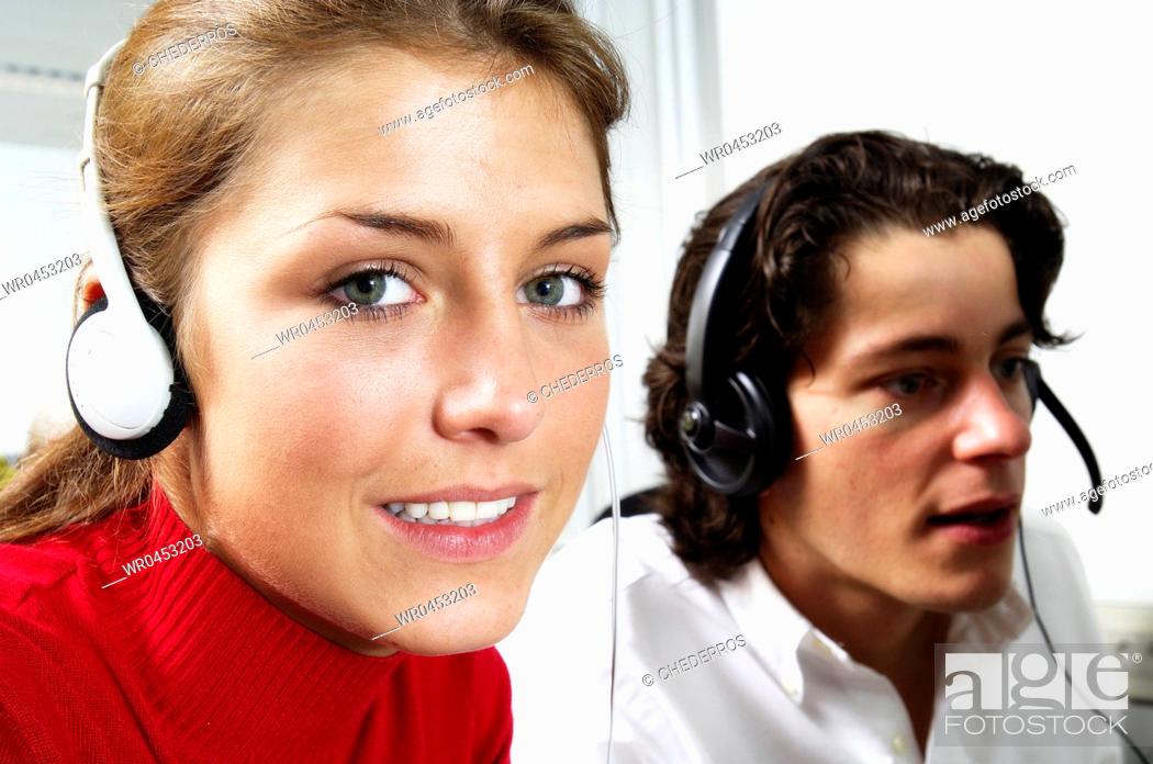 Stock Photo: Close-up of a teenage girl wearing headphones with a teenage boy wearing a headset beside her.