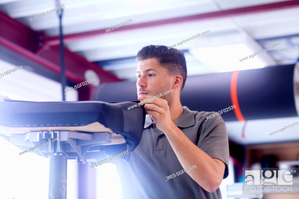 Stock Photo: Young man working in a upholstery workshop.