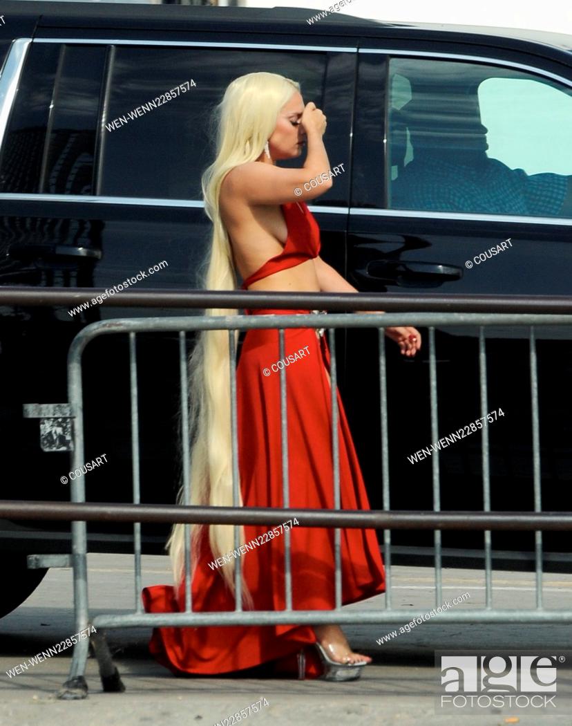 Stock Photo: Lady Gaga leaves little to the imagination as she steps out of her trailer in a red dress with a long slit that showed off her toned legs for a scene in.