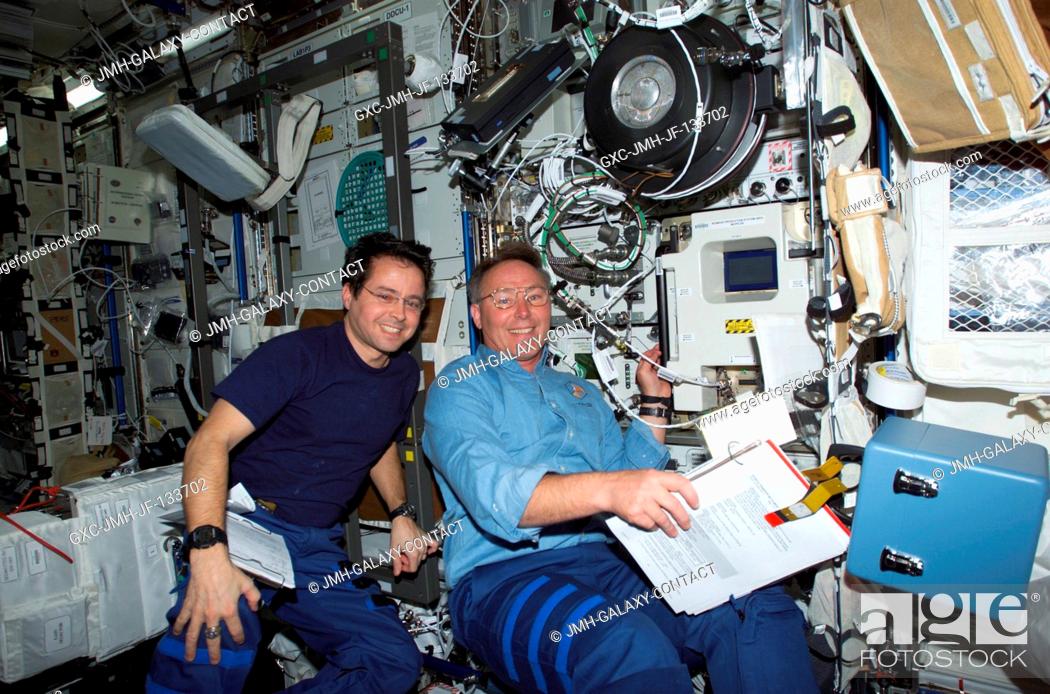 Imagen: Astronauts Daniel W. Bursch (left), Expedition Four flight engineer, and Jerry L. Ross, STS-110 mission specialist, work in the Destiny laboratory on the.