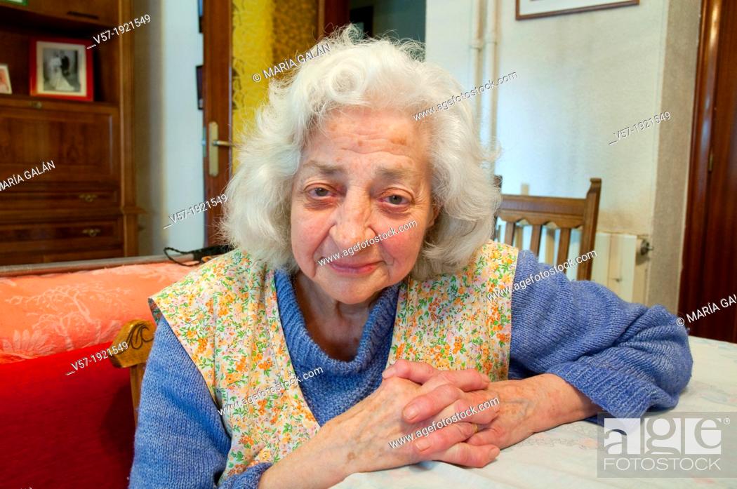 Photo de stock: Portrait of elderly woman at home, smiling and looking at the camera.
