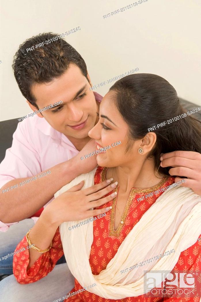 Stock Photo: Man putting a necklace on a woman's neck.