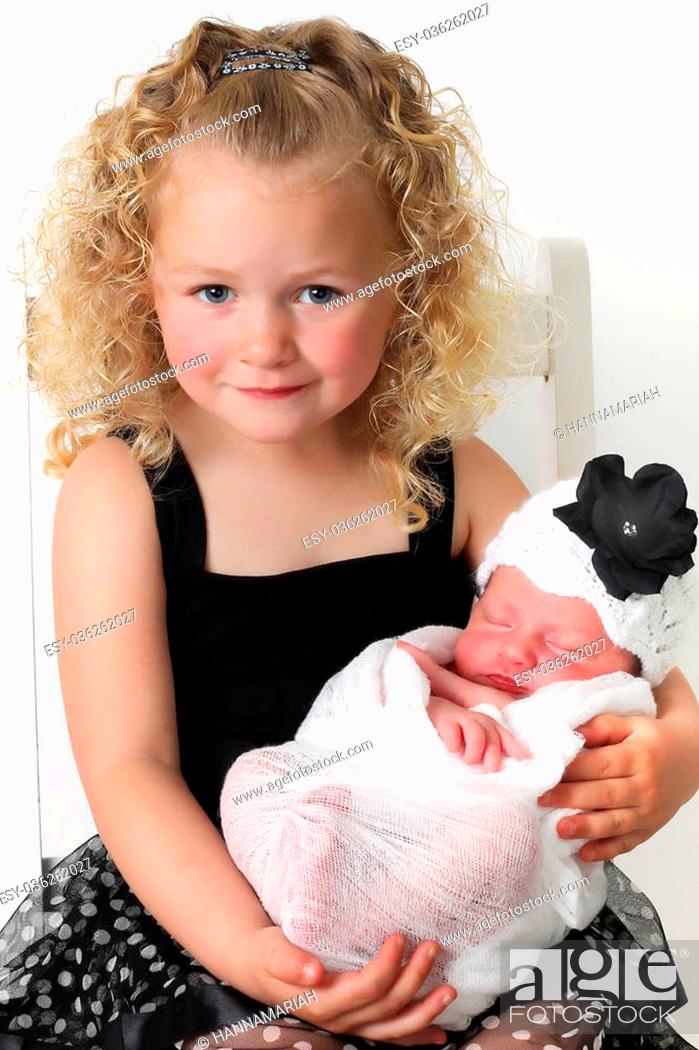 Stock Photo: Beautiful blond girl, holding her newborn baby sister.