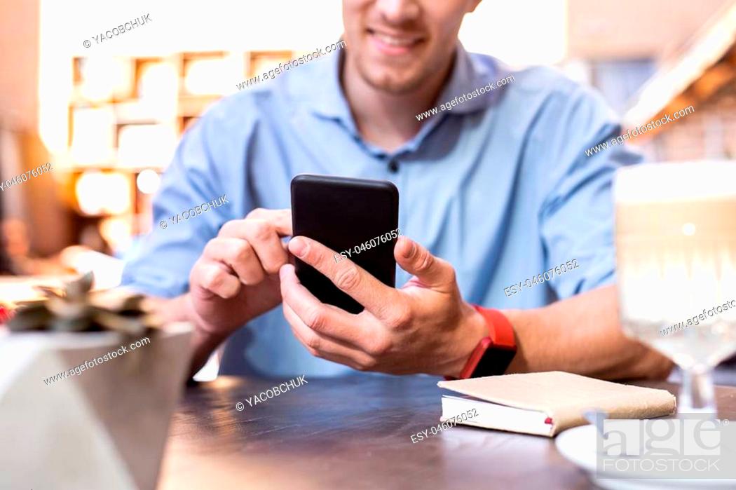 Stock Photo: Making notes. Beaming occupied businessman feeling a little bit busy while making some important notes on phone.