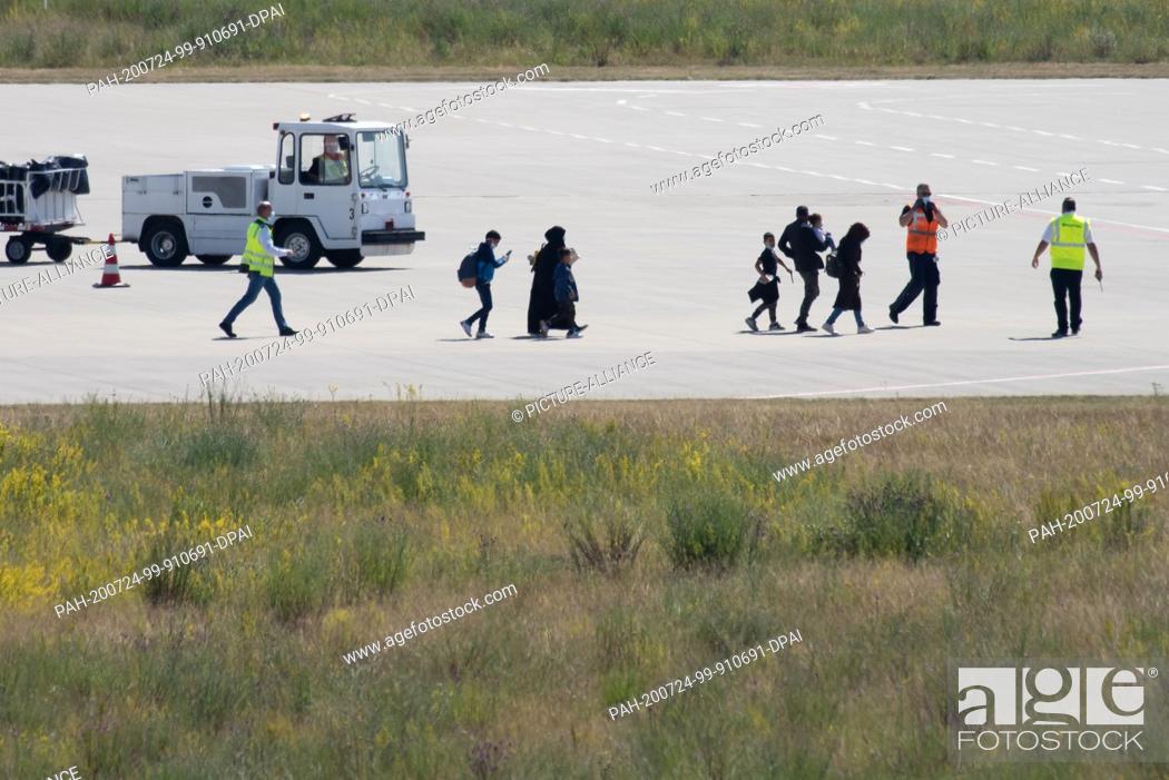Stock Photo: 24 July 2020, Hessen, Calden: Refugees from Greek refugee camps get off the plane at Kassel-Calden (Kassel Airport). The German government has brought a group.