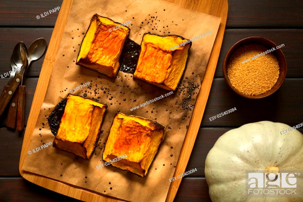 Stock Photo: Baked pumkin pieces with caramelized sugar on top, a traditional autumn snack in Hungary, photographed overhead on dark wood with natural light.