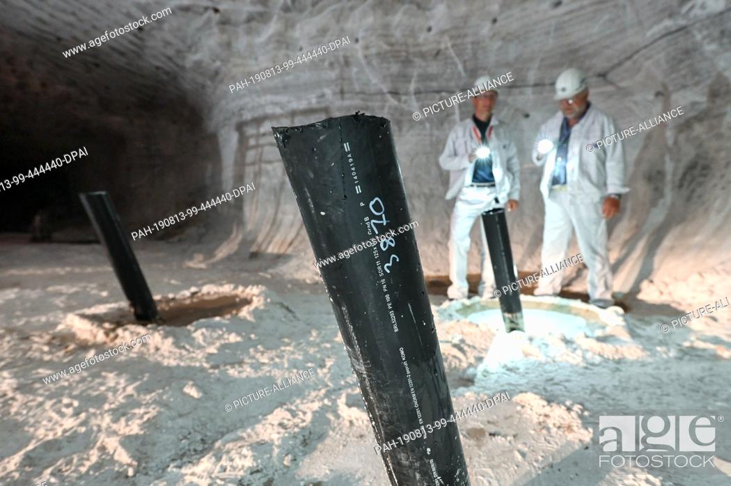 Stock Photo: 12 August 2019, Hessen, Philippsthal: In the Hesse-Thuringia potash district, three drain pipes protrude from the deepest point of the reservoir at a depth of.