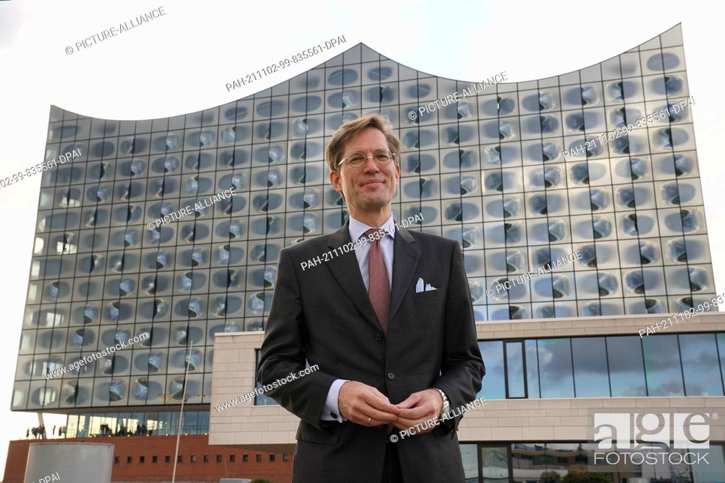 Stock Photo: 02 November 2021, Hamburg: Nils Weiland, deputy chairman of the Hamburg SPD, stands on a roof terrace in front of the Elbphilharmonie concert hall in Hafencity.