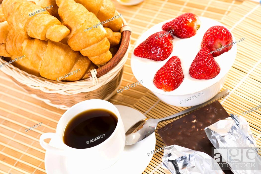 Imagen: continental breakfast: coffee, strawberry with cream, croissant.