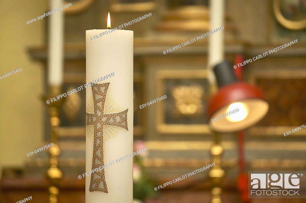 Stock Photo: Horizontal shot of an Easter candle with the cross lit in the church during the ceremony of a baptism.