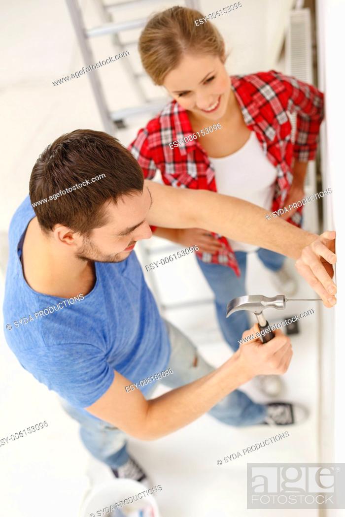 Stock Photo: repair, building and home concept - smiling couple renovating new home.