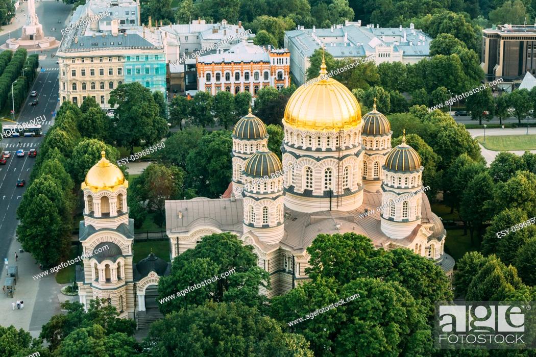 Stock Photo: Riga, Latvia. Riga Cityscape. Top View Of Riga Nativity Of Christ Cathedral - Famous Church And Landmark In Summer Evening. Golden Yellow Domes.