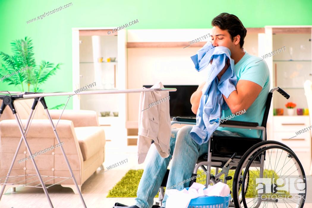 Imagen: Disabled man on wheelchair doing laundry.