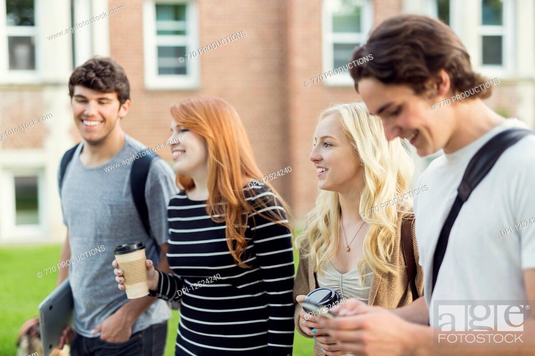 Stock Photo: Four friends walking and talking together on the university campus; Edmonton, Alberta, Canada.