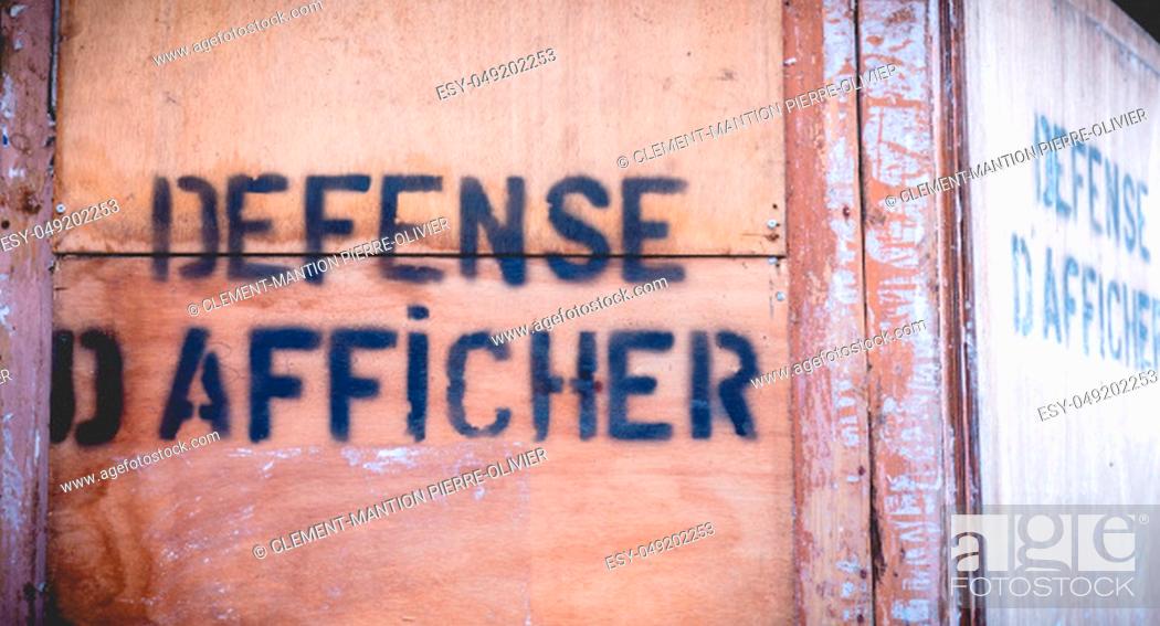 Stock Photo: stick no bills written in french in black paint on a wooden wall.