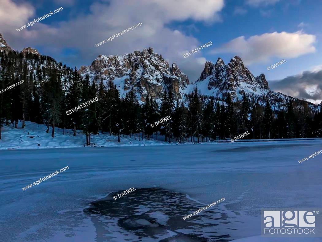 Stock Photo: Frozen alpine lake and mountain landscape at dusk, Cadini mountains, Italy.