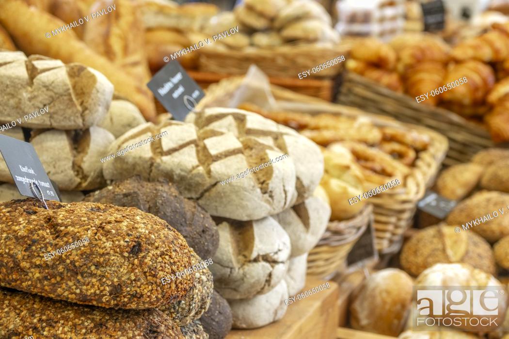 Stock Photo: Netherlands. Farmers market in Amsterdam. Many types of breads and croissants. The sign in the foreground reads ""Garlic, sun-dried tomato"" in Dutch.