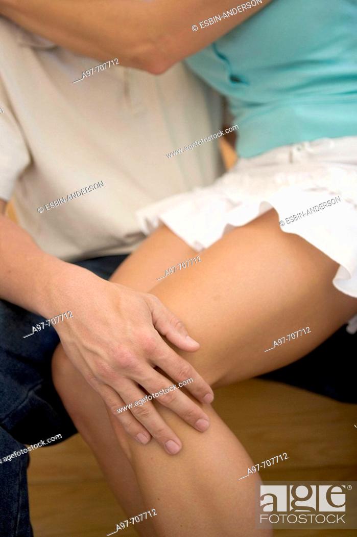 Stock Photo: Close-up of mans hand on attractive female legs.