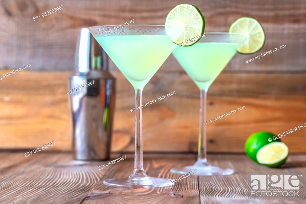 Stock Photo: Two cocktail glasses of classic daiquiri on the wooden background.