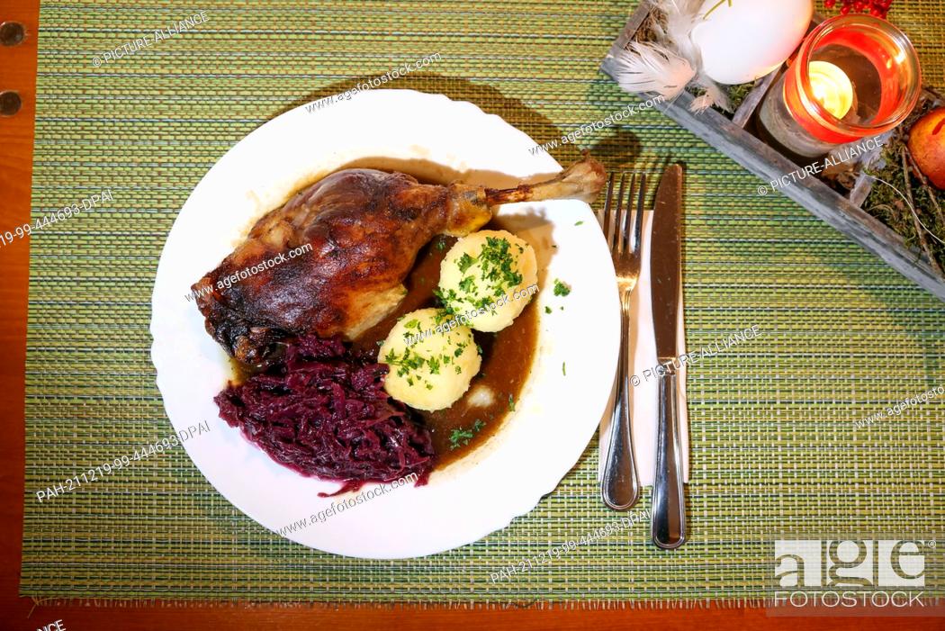 Stock Photo: 13 December 2021, Saxony, Wermsdorf: A portion of goose leg with red cabbage and dumplings stands on a table in the restaurant of the Eskildsen goose farm.