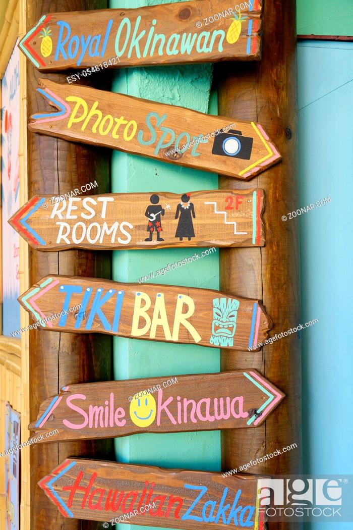 Stock Photo: Wooden signs where is inscribed Royal Okinawan, Rest Rooms, Tiki Bar, Smile Okinawa, Hawaiian Zakka in the shop mall of the American village of Chatan City in.