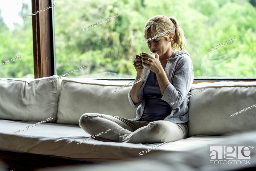 Stock Photo: Mature woman having coffee at home.