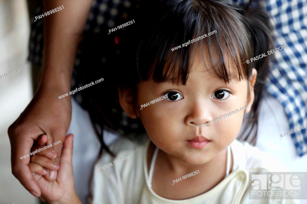 Stock Photo: Bahnar (Ba Na) ethnic group. Young girl hording the hand of her mother. Portrait. Kon Tum. Vietnam. | usage worldwide. - Kon Tum/Kon Tum/Vietnam.