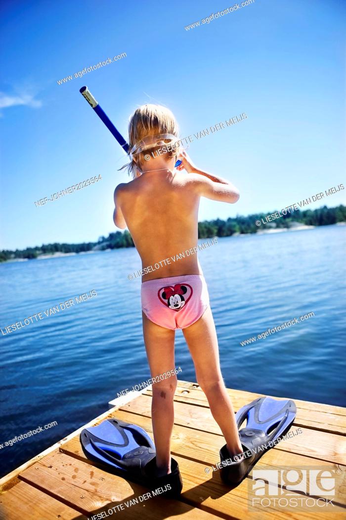 Stock Photo: Boy on jetty wearing swim-fins and scuba mask.