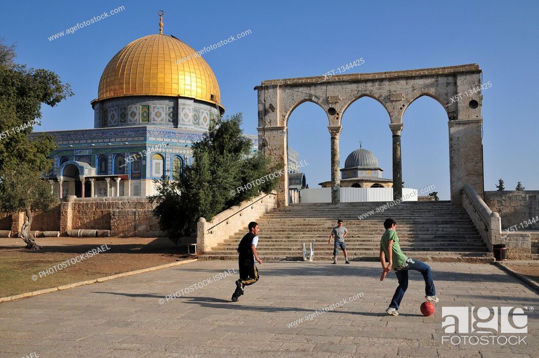 Stock Photo: Israel, Jerusalem Old City, Dome of the Rock on Haram esh Sharif Temple Mount a Qanatir The Arch in the foreground  Arab children play soccer.