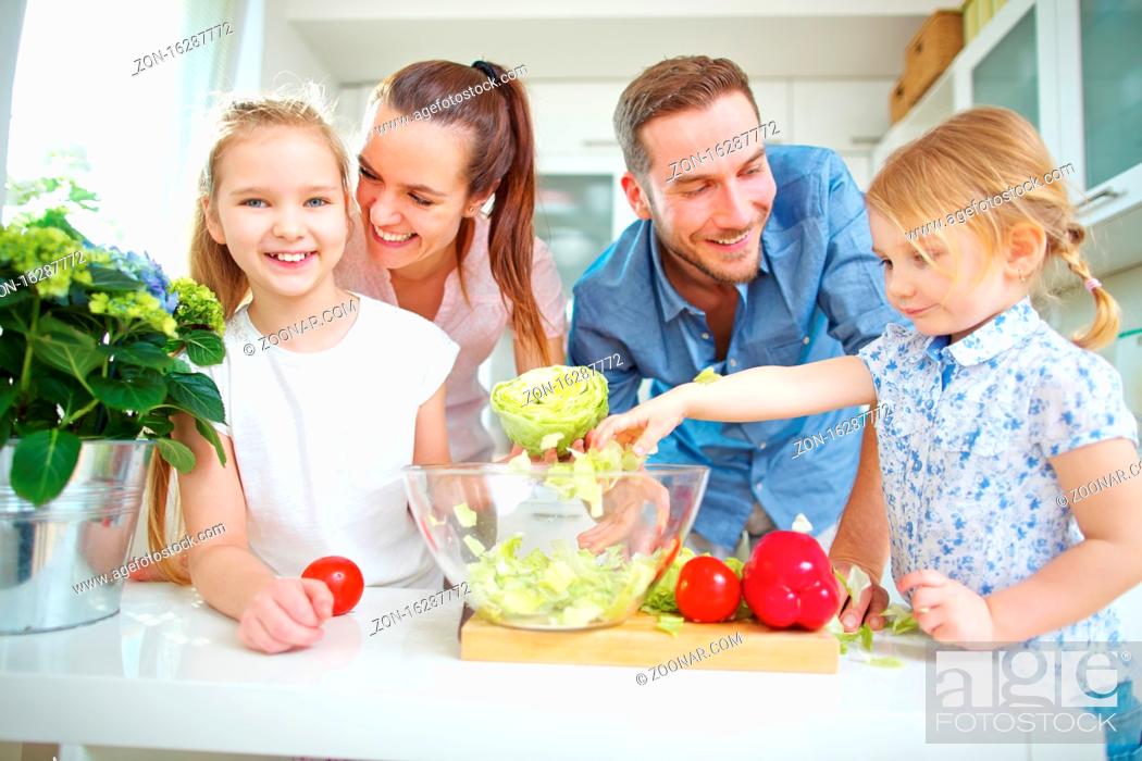 Stock Photo: Familie und zwei Kinder machen zusammen frischen Salat in der Küche.
