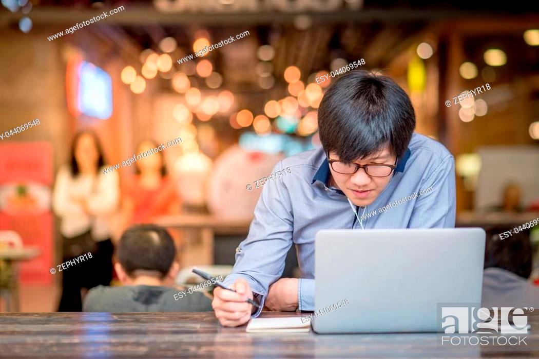 Stock Photo: Young Asian Business man dressed in casual style contact with customer when working in cafe. Digital nomad lifestyle in public working space.