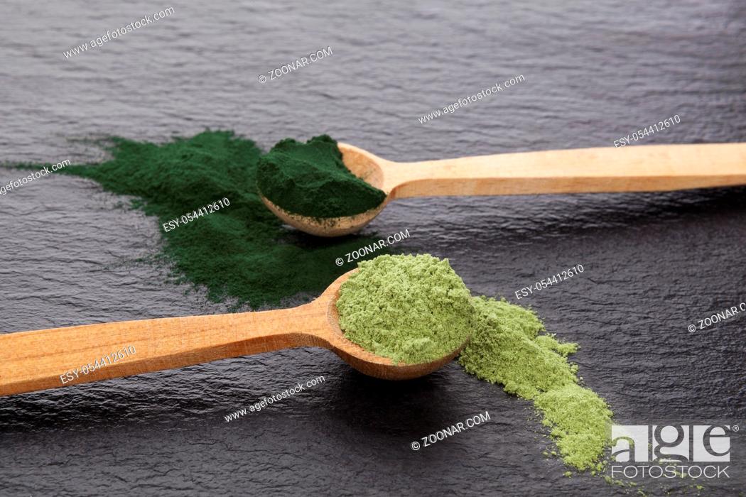 Stock Photo: Chlorella and barley grass powder on black background. Detox and superfood concept.