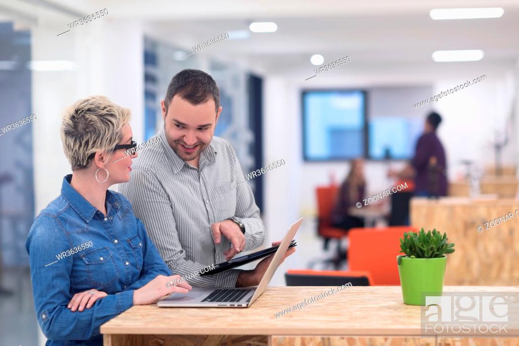 Stock Photo: startup business team on meeting in modern bright office interior brainstorming, working on laptop and tablet computer.