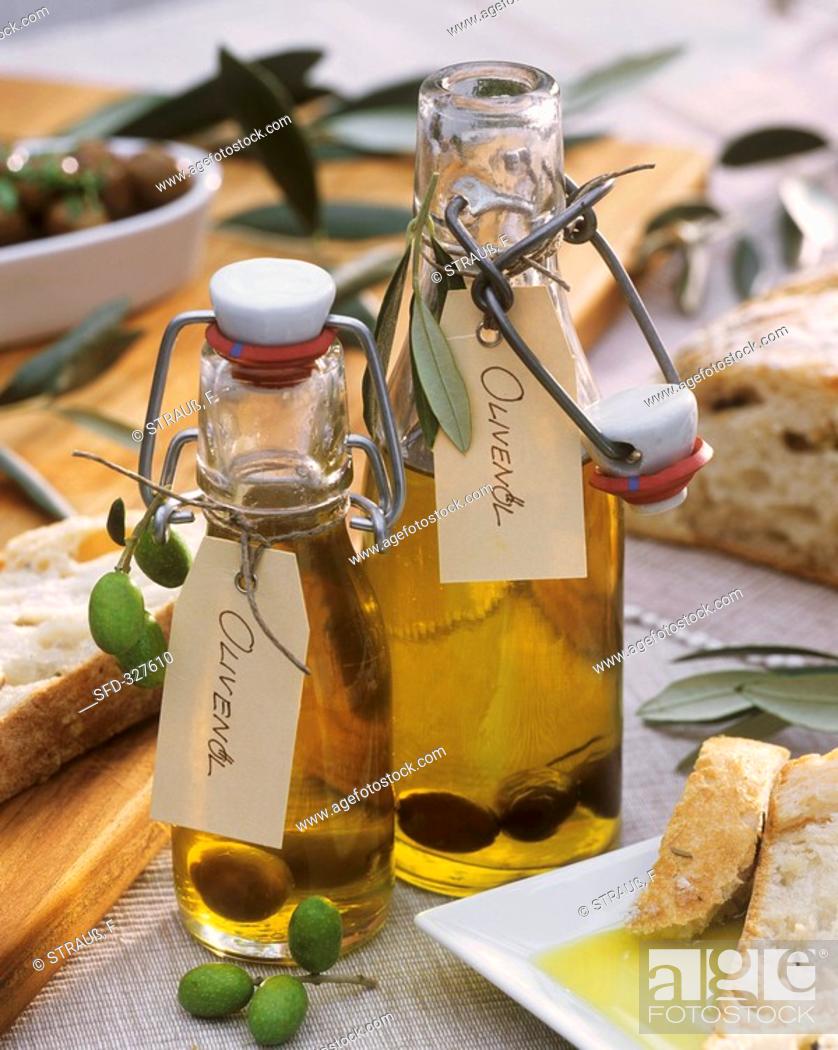 Stock Photo: Two bottles of olive oil, marinated olives, ciabatta.