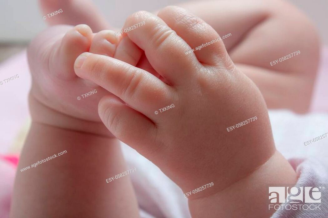 Stock Photo: Family photo showing a baby exploring her toes.