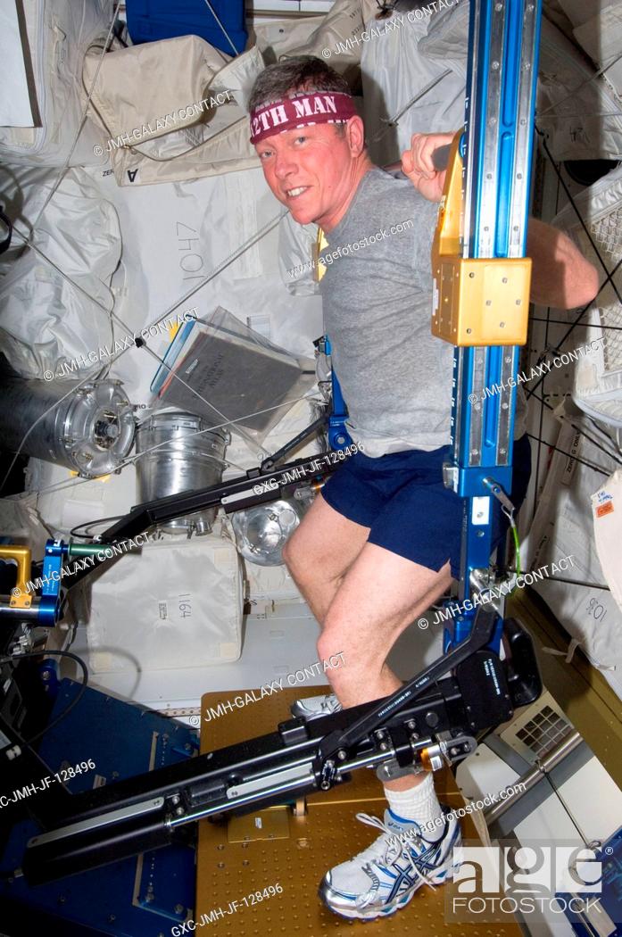 Stock Photo: NASA astronaut Mike Fossum, Expedition 29 commander, exercises using the advanced Resistive Exercise Device (aRED) in the Tranquility node of the International.