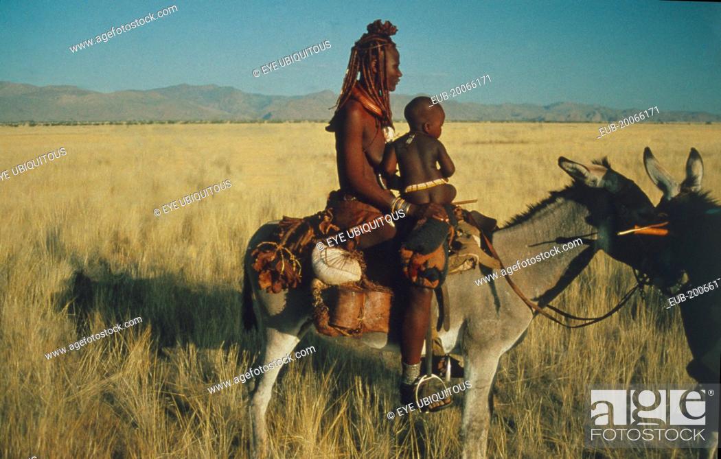 Himba nomad woman and child in traditional leather clothing crossing the  Marienfluss on donkey in..., Stock Photo, Picture And Rights Managed Image.  Pic. EUB-20066171 | agefotostock