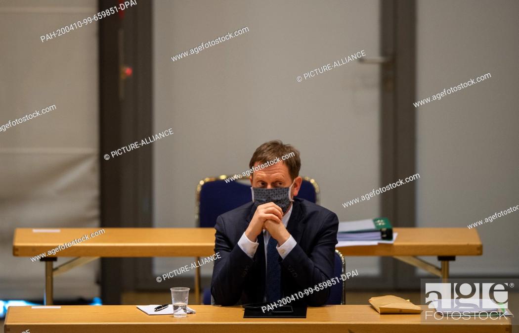Stock Photo: 09 April 2020, Saxony, Dresden: Michael Kretschmer (CDU), Prime Minister of Saxony, sits in his seat with a mouth guard during a special session of the Saxon.