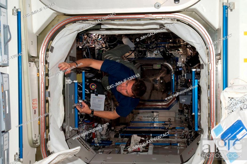 Stock Photo: NASA astronaut Reid Wiseman, Expedition 40 flight engineer, floats through the hatch between the Destiny laboratory and the Unity node of the International.