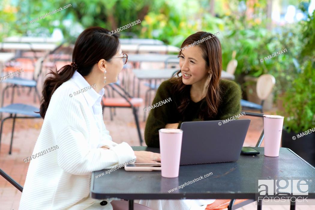 Stock Photo: Two women having meeting in open space office.