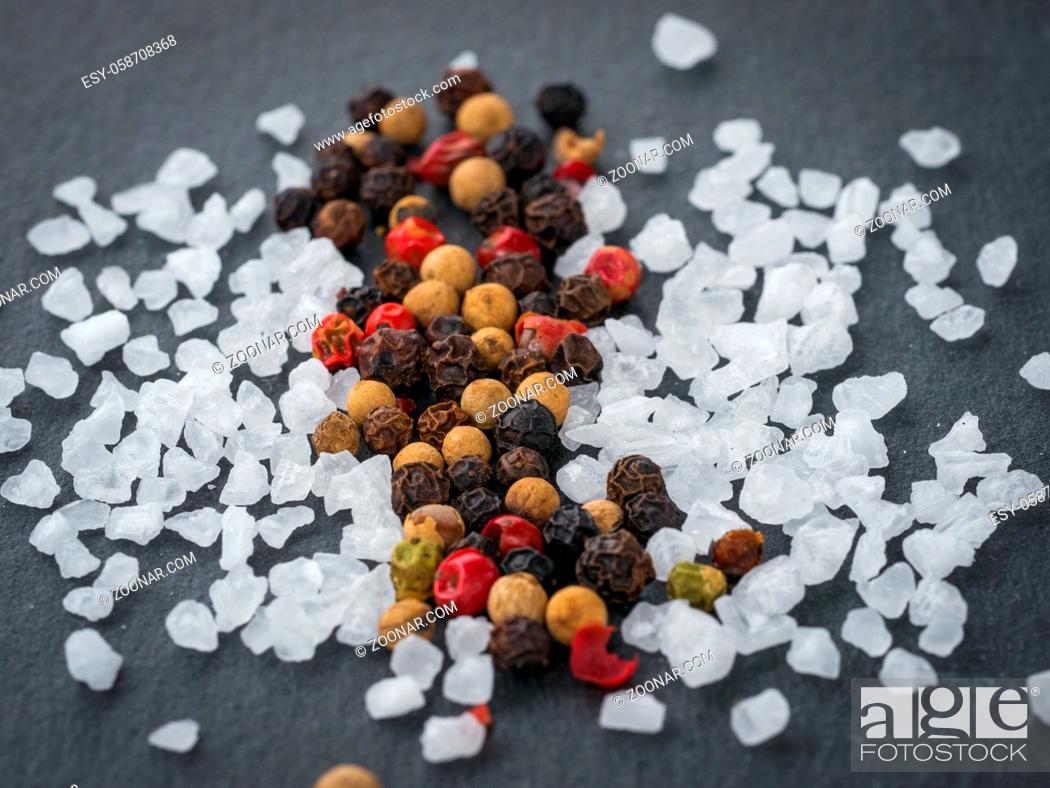 Stock Photo: Coarse sea salt and peppercorns on slate background.Close up. Food background.