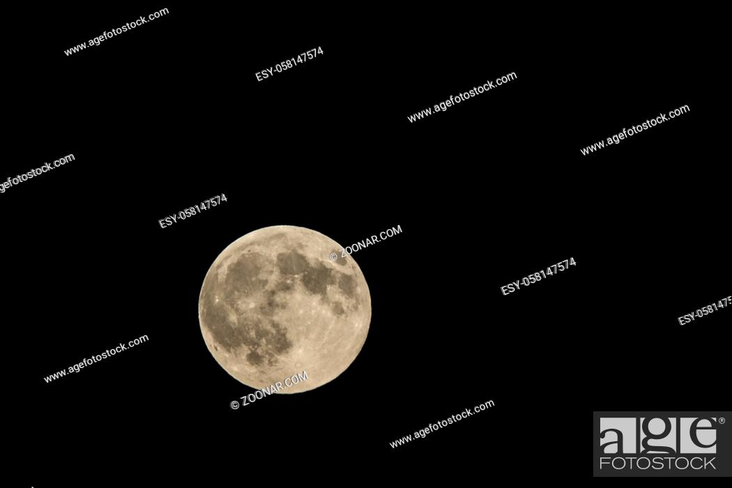 Photo de stock: Full moon over dark black sky at night.