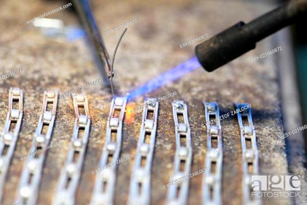 Stock Photo: Cloceup jeweller at work silver soldering.