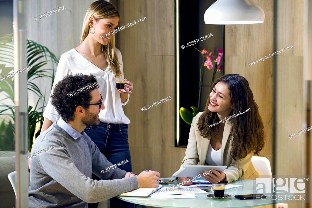 Stock Photo: Three happy business people having a meeting in modern office.